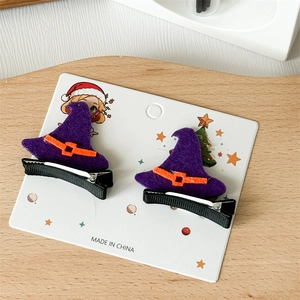 Detail of two purple wizard hat hair clips with orange ribbons on a display card
