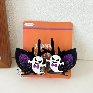 Detail view of two glittery Halloween ghost hair clips with purple accents on card