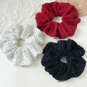 Detailed close-up of retro polka dot scrunchie set in white red and black colors