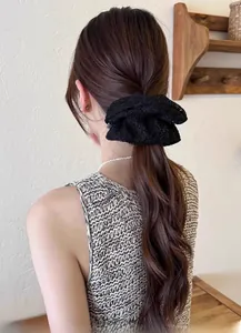 Detail of elegant black lace scrunchie on low ponytail with intricate mesh pattern