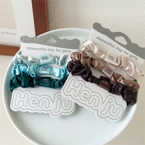 Detailansicht bunter Satin-Haargummis-Set mit eleganten Verpackungskarten für Mädchen