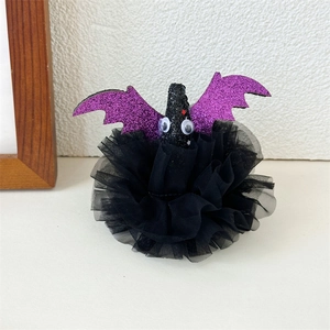 Detail showing a Halloween purple glitter bat hair clip with black mesh ruffles and googly eyes