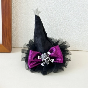 Detail of Halloween witch hat clip with silver stars, purple bow and skull decoration