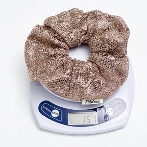 Elegant champagne mesh scrunchie with metallic finish shown on a scale at 15.7g