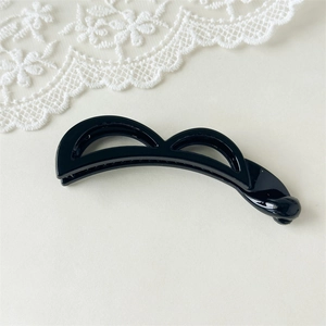 Detail eines glänzenden schwarzen Bananen-Haarclips mit hohlem Doppelbogendesign