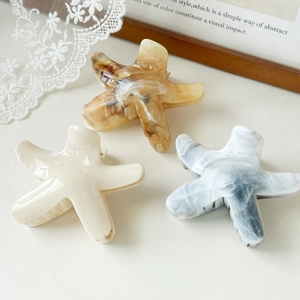 Three-piece starfish hair claws set in amber, creamy white, and marble blue acetate
