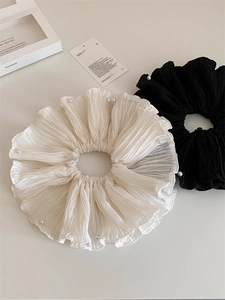 Détail de chouchous plissés élégants avec perles en coloris crème et noir