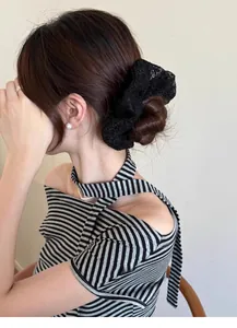 Detail of elegant black lace scrunchie on hair bun with high elasticity and pearl jewelry