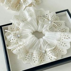 Elegant cream lace hair scrunchie with satin bows and pearls in a display tray