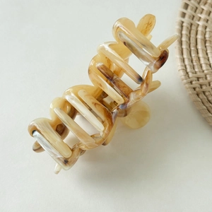 Macro view of large marble texture amber hair claw clip on neutral background