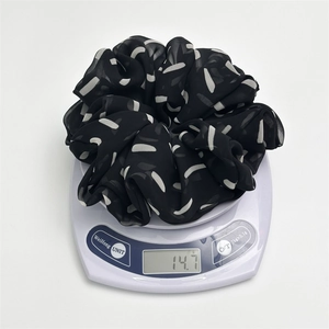Black and white striped oversized chiffon scrunchie shown on a scale weighing 14.7g