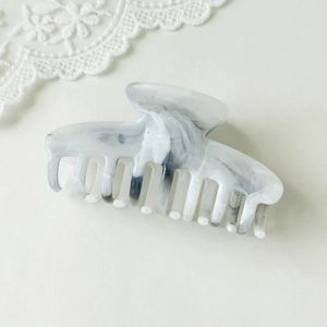 Detail of large claw clip with elegant black and white marble ink texture for hair styling