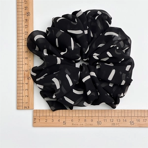 Top view of large black and white striped chiffon hair scrunchie with measuring scale