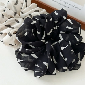 Detail of large black and white striped chiffon scrunchies with soft pleated texture