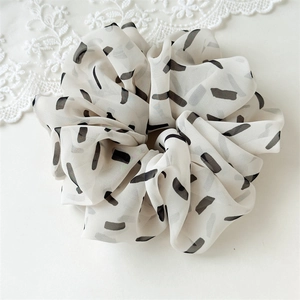 Modern white chiffon hair scrunchie with black stripe print on minimalist lace background