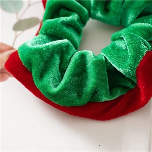 Close-up of plush red and green velvet Christmas scrunchies with elastic texture