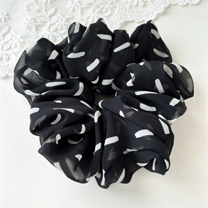 Detailed view of the black and white striped chiffon scrunchie texture with lace