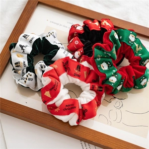 Close-up of velvet Christmas scrunchies with festive reindeer and Santa patterns