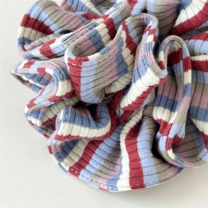 Detail of colorful striped ribbed fabric scrunchie with durable elastic band and clean stitching