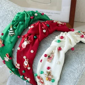 Detailed view of handmade knotted satin headbands with pearls and Christmas charms