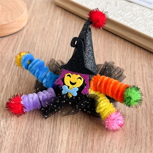 Détail d'une pince à cheveux chapeau de sorcière Halloween avec voile et pompons