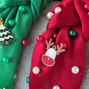 Detail of Christmas knot headband with pearls, red and green satin fabric with holiday charms