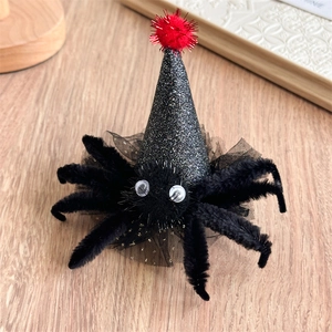 Détail d'une pince à cheveux d'Halloween avec araignée en peluche et chapeau de sorcière