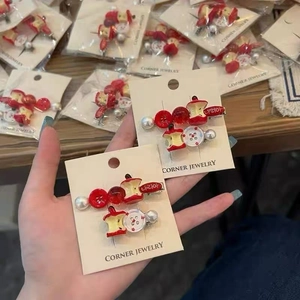 Detail of red apple resin hair clips with faux pearls and buttons on a display card