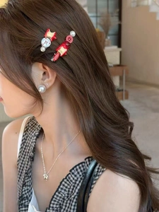 Detail showing red apple hair clip and cartoon pearl hairpin set on a female model