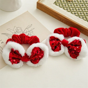 Detail of red velvet Christmas bow hair ties with white plush edges and sequins