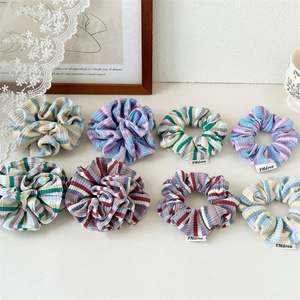 Flat lay of colorful striped knitted scrunchies with soft ribbed texture and sweet style