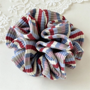 Close-up of colorful ribbed knit fabric scrunchie with multi-color horizontal stripes