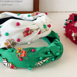 Detailed close-up of handmade Christmas pearl headbands with festive enamel charms