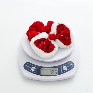 Detail showing weight of plush red velvet Christmas scrunchie with white faux fur and sequins