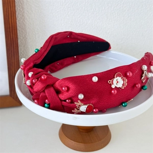 Detail of red satin knotted headband with pearls, Santa and reindeer metal charms