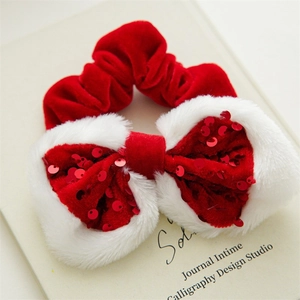 Detail of red velvet Christmas bow scrunchie with white faux fur and red sequins