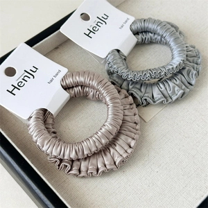 Close-up of champagne and silver grey satin scrunchies on a display tray