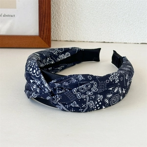 Detalle del diseño con nudo trenzado y estampado de cachemira en diadema de tela