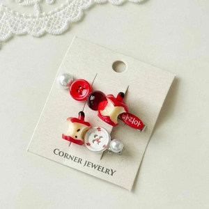 Detail view of cute red apple and white pearl hair clips on a jewelry display card