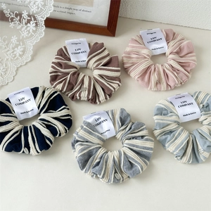 Detail view of colorful striped knit scrunchies set with premium texture and tags