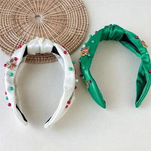 Detail of Christmas knot headband with pearls, metallic snowflakes, and small bells