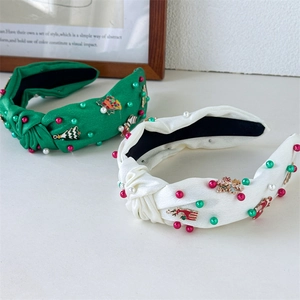 Close-up of handmade knotted satin headbands with pearls and Christmas charms