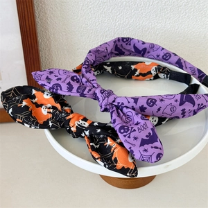 Close-up of Halloween bunny ear headbands with pumpkin and skull prints on ceramic plate