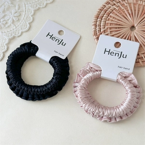 Elastic satin scrunchies in black and champagne pink on elegant lace background