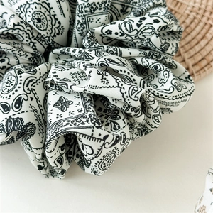 Nahaufnahme des schwarz-weißen Paisley-Haargummis mit weicher Textur und Muster