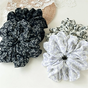 Detail of oversized fabric scrunchies with elegant ink floral patterns and textures
