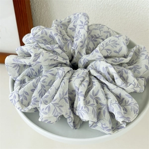 Detailed macro view of an oversized scrunchie featuring elegant purple ink floral prints