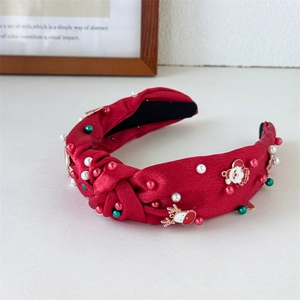 Detail of red satin knotted headband with pearls and Christmas enamel charms