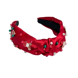 Red knotted satin Christmas headband decorated with festive pearls and holiday charms