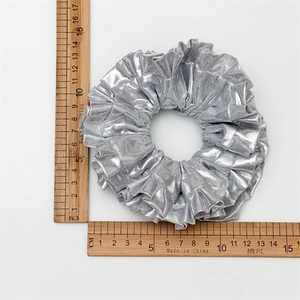 Silver metallic scrunchie measuring approximately 11.5cm in diameter on a wooden ruler